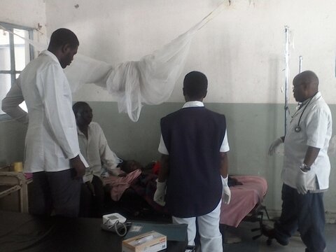 Dr Fayulu (right) and Male ward team discuss the case of a severe malaria patient.